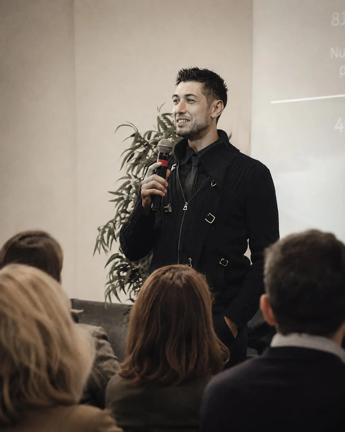 Simone Sampalmieri sul palco con il microfono durante un intervento pubblico
